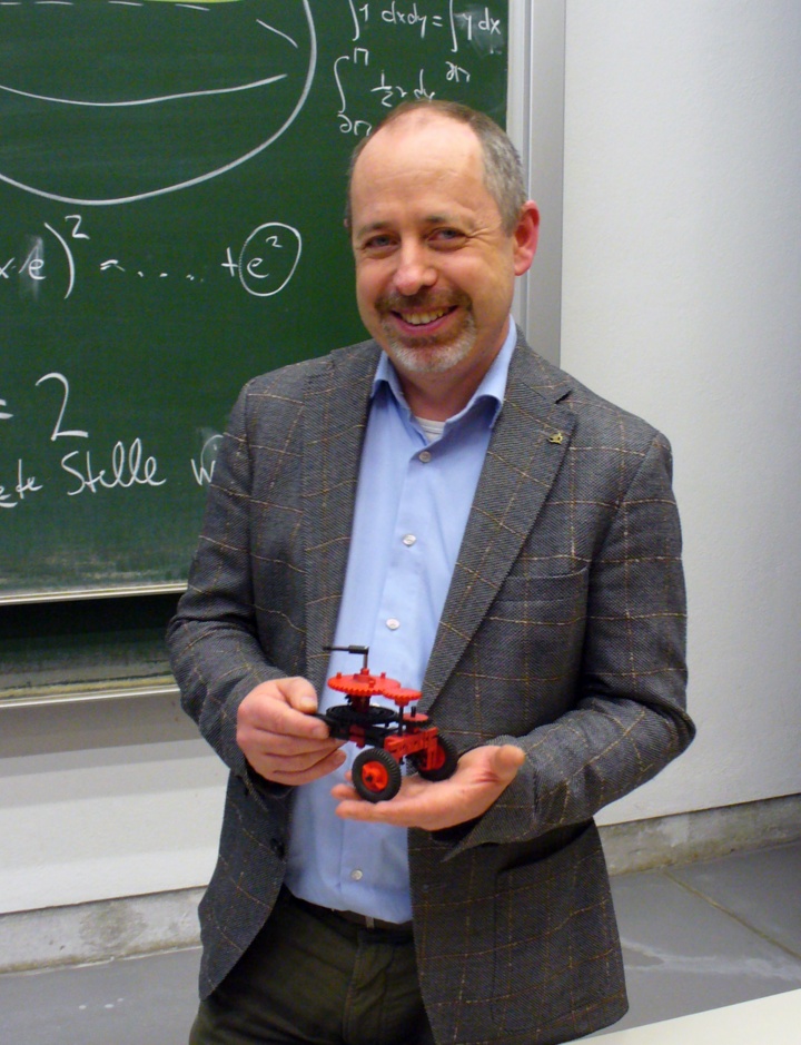 Prof. Jens Wirth mit dem Neuzugang der Sammlung mathematischer Instrumente: einen Kompasswagen aus fischertechnik. 